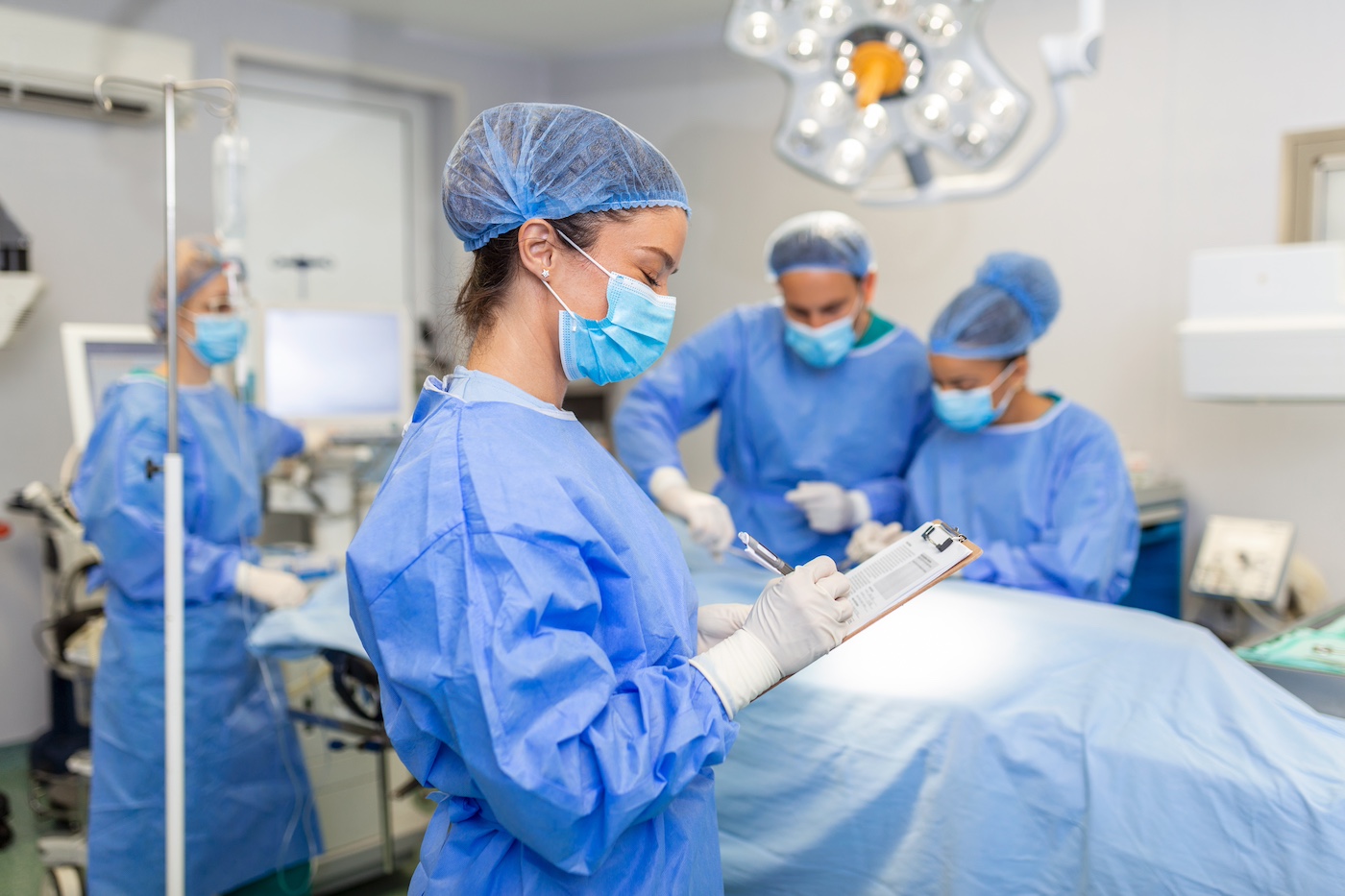An anesthesiologist holds a clipboard in an OR